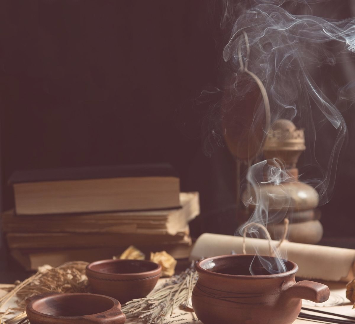 De la fumée de purification s'élève au-dessus de bols en terre